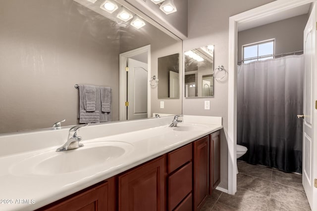 full bath with double vanity, tile patterned flooring, toilet, and a sink