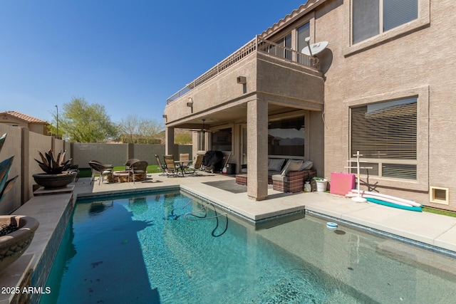 view of swimming pool featuring a fenced in pool, a ceiling fan, a fenced backyard, an outdoor living space with a fire pit, and a patio area