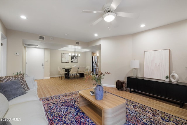 living room with baseboards, visible vents, wood finished floors, and recessed lighting