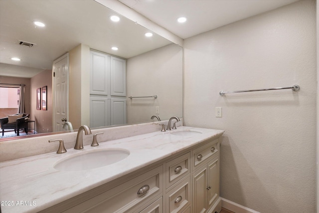full bath featuring double vanity, a sink, visible vents, and recessed lighting