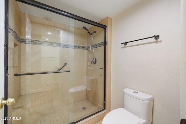 bathroom with a shower stall and toilet