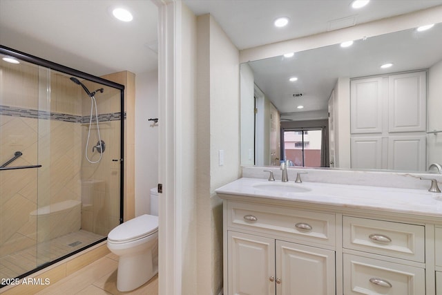 bathroom featuring toilet, recessed lighting, a sink, double vanity, and a stall shower
