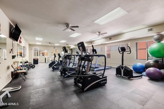 exercise room with a ceiling fan, visible vents, and a textured ceiling