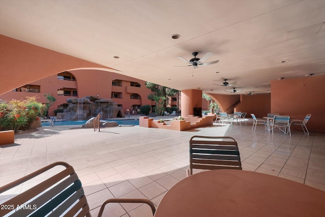 view of patio with ceiling fan, a community pool, and outdoor dining space