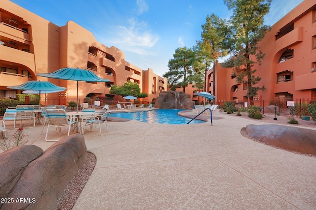community pool with fence and a patio