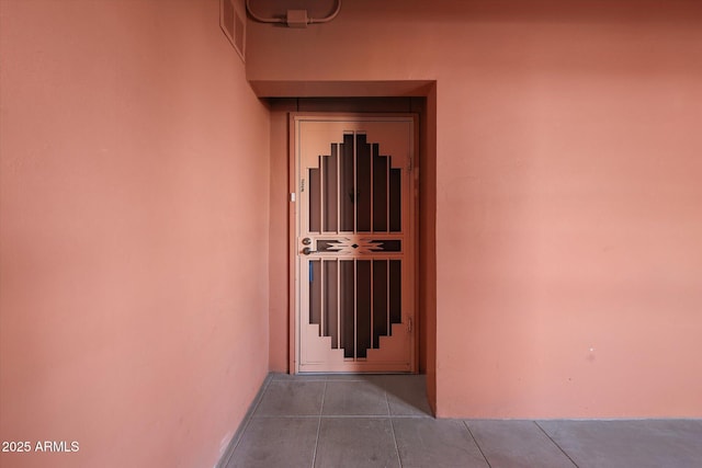 corridor featuring tile patterned flooring and visible vents