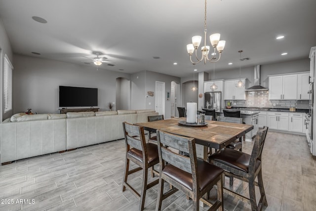 dining room with ceiling fan with notable chandelier and light hardwood / wood-style flooring