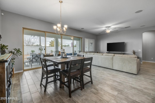 dining space featuring ceiling fan with notable chandelier and light hardwood / wood-style floors