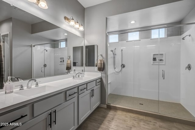 bathroom featuring a shower with door, vanity, and wood-type flooring