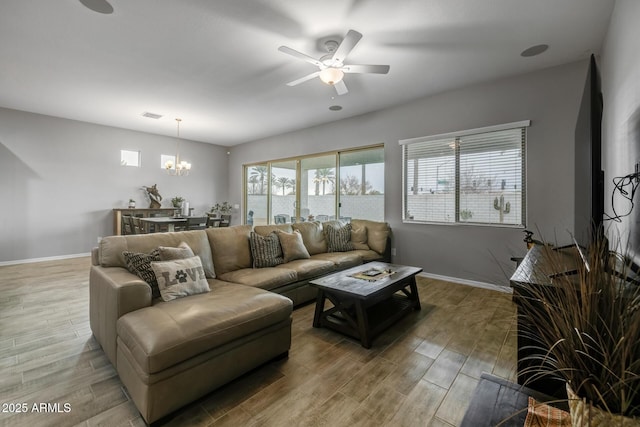 living room with wood-type flooring, plenty of natural light, and ceiling fan with notable chandelier