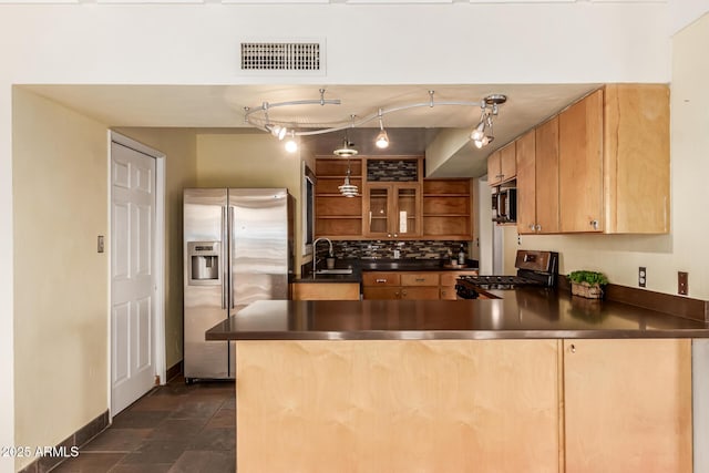 kitchen featuring appliances with stainless steel finishes, rail lighting, kitchen peninsula, and sink