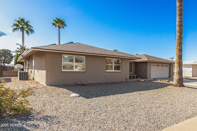 ranch-style house featuring central AC and a garage