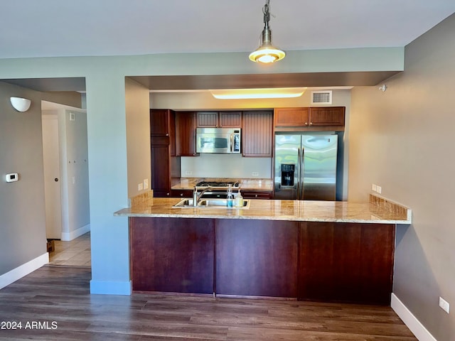 kitchen with kitchen peninsula, dark hardwood / wood-style flooring, and stainless steel appliances