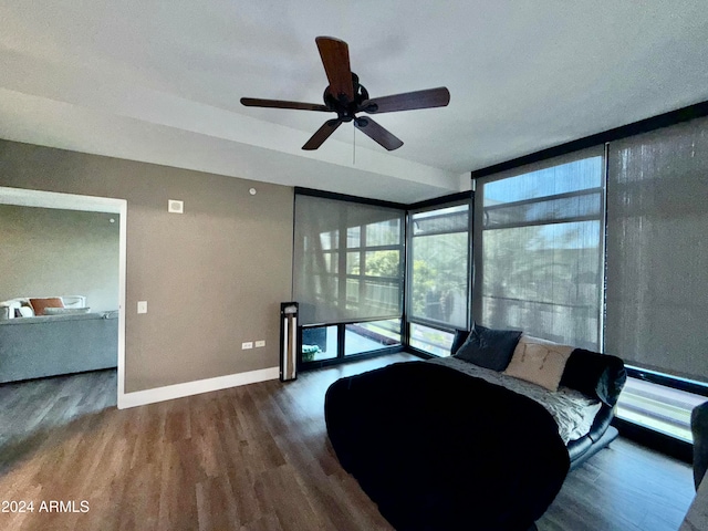 living room featuring expansive windows, hardwood / wood-style flooring, and ceiling fan