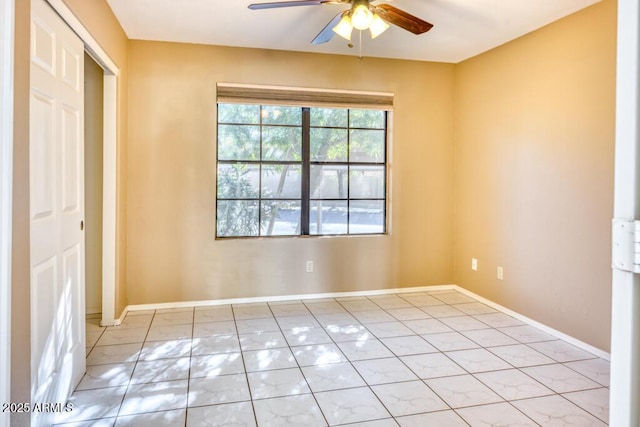 unfurnished room featuring ceiling fan and baseboards