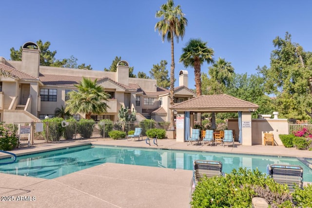 community pool featuring a gazebo, fence, and a patio area