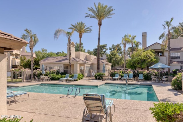 community pool featuring fence and a patio area