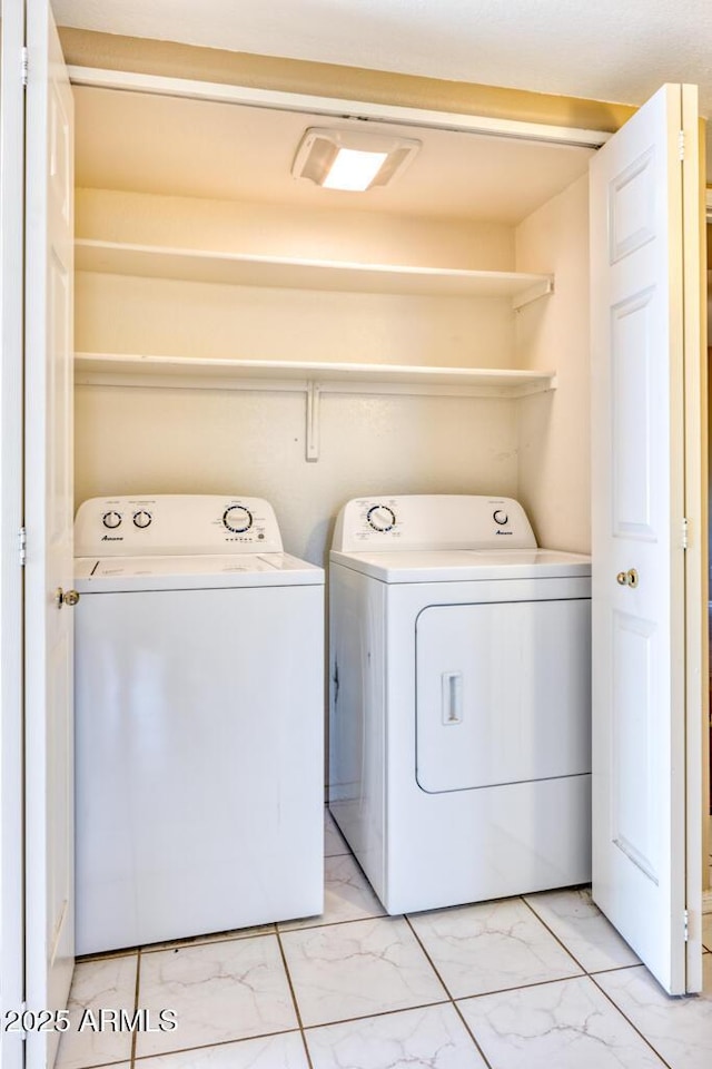 laundry room featuring independent washer and dryer and light marble finish flooring
