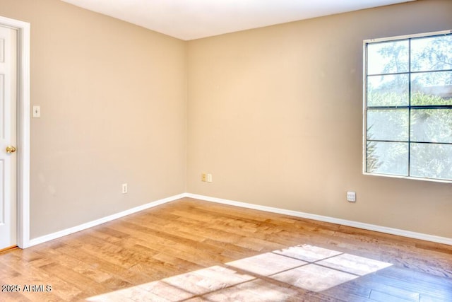 unfurnished room with light wood finished floors and baseboards