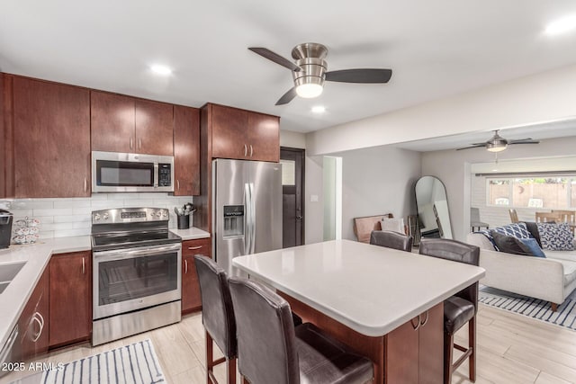 7727 E 4th St, Scottsdale, AZ 85251 - kitchen with light countertops, appliances with stainless steel finishes, a breakfast bar, and a ceiling fan