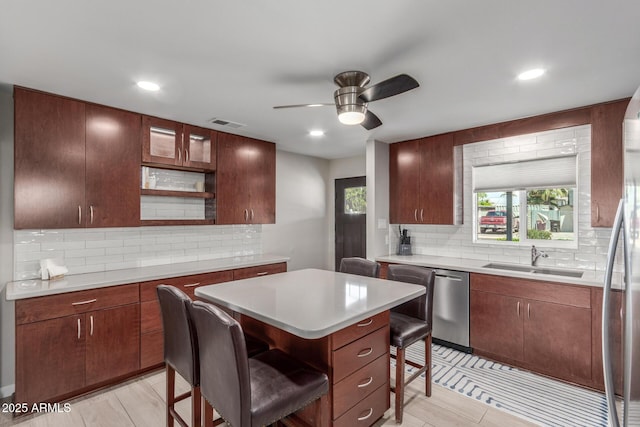 7727 E 4th St, Scottsdale, AZ 85251 - kitchen featuring a sink, backsplash, a kitchen bar, and stainless steel appliances