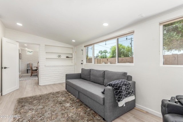 7727 E 4th St, Scottsdale, AZ 85251 - living area featuring light wood-type flooring, built in features, lofted ceiling, and a healthy amount of sunlight
