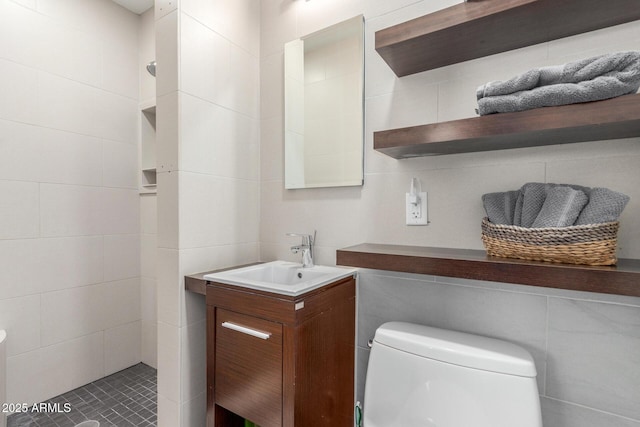 7727 E 4th St, Scottsdale, AZ 85251 - bathroom with vanity, tiled shower, toilet, and tile walls