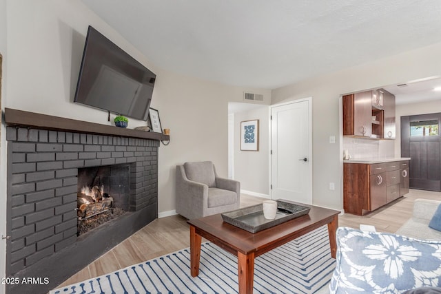 7727 E 4th St, Scottsdale, AZ 85251 - living area featuring baseboards, a fireplace, light wood-type flooring, and visible vents