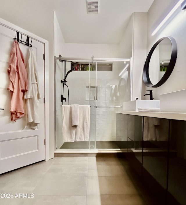 full bathroom with tile patterned flooring, visible vents, a shower stall, and vanity