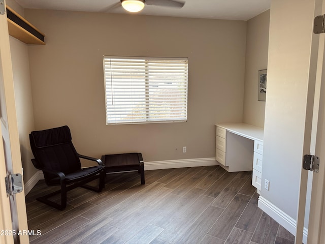 sitting room featuring a ceiling fan, baseboards, built in study area, and wood finish floors