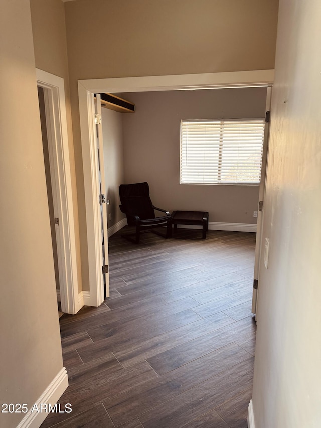 hallway with dark wood-style floors and baseboards