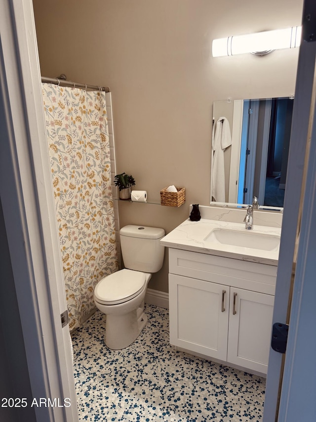 full bath with toilet, baseboards, a shower with shower curtain, and vanity