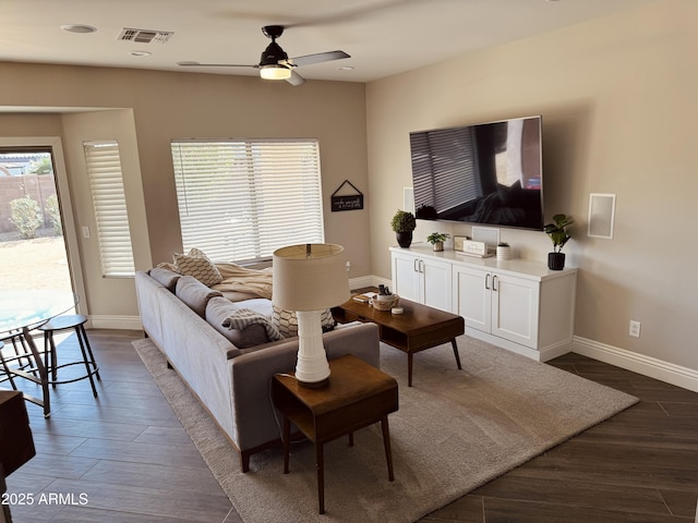 living room with baseboards, visible vents, and dark wood-style flooring