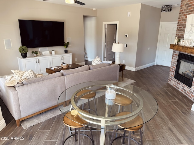 living room featuring ceiling fan and a fireplace