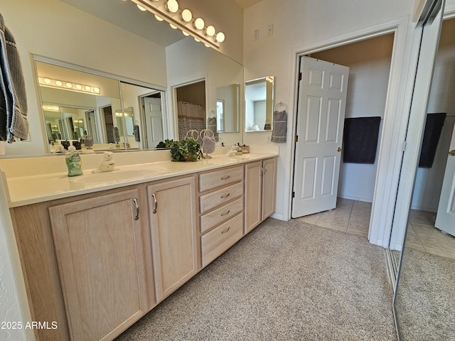 full bath featuring carpet, double vanity, a sink, and tile patterned floors