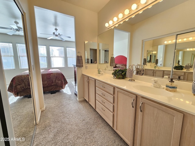 full bathroom featuring carpet floors, double vanity, ensuite bathroom, a sink, and baseboards