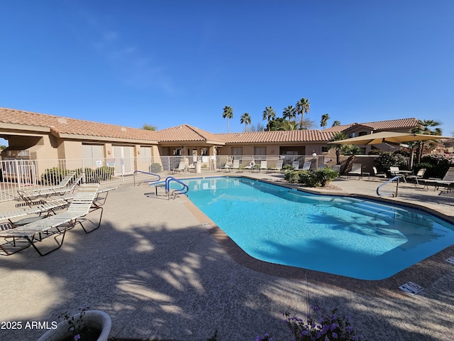 community pool featuring fence and a patio