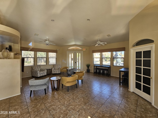 living area featuring dark tile patterned floors, baseboards, a ceiling fan, and french doors