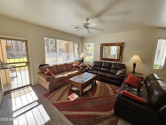 living room with visible vents, wood finished floors, and a ceiling fan