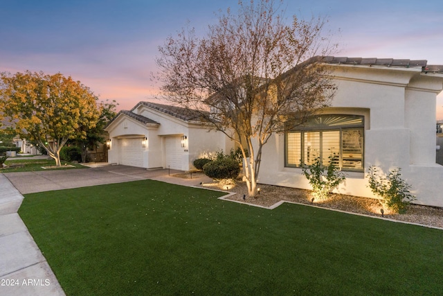 view of front of home featuring a lawn and a garage