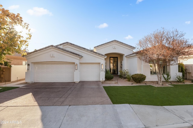 mediterranean / spanish-style home featuring a front yard and a garage