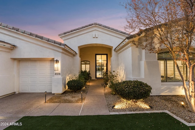 exterior entry at dusk with a garage