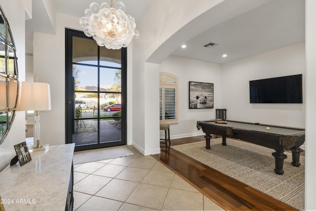 entryway with a notable chandelier, light tile patterned floors, and billiards