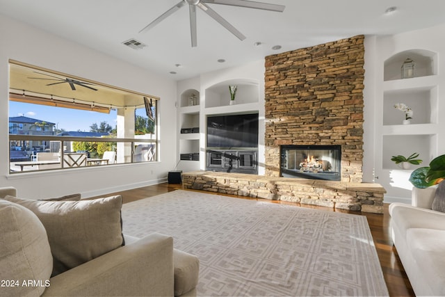 living room featuring a fireplace, built in features, ceiling fan, and hardwood / wood-style flooring