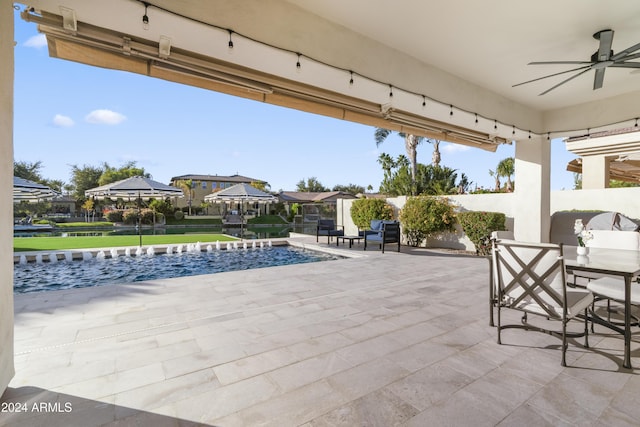 view of patio / terrace featuring ceiling fan and pool water feature