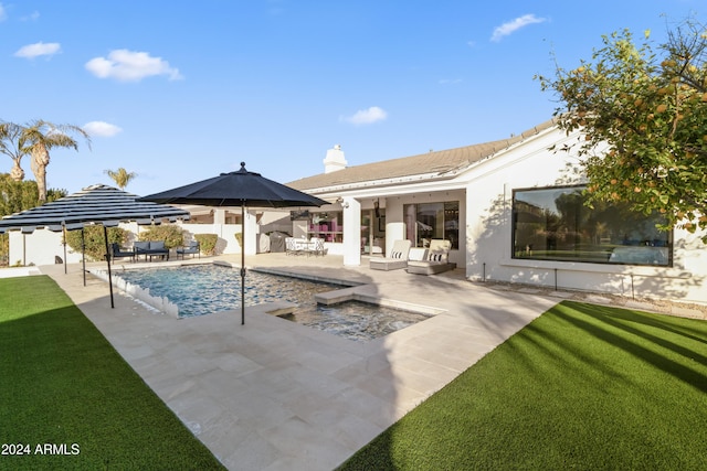 view of pool featuring a jacuzzi, a lawn, and a patio area