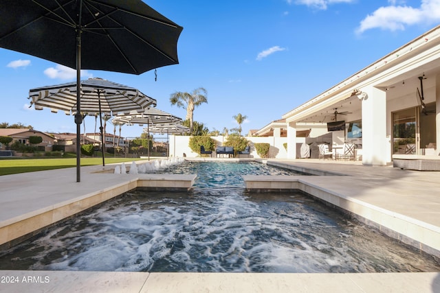 view of swimming pool with a patio area, ceiling fan, pool water feature, and a hot tub