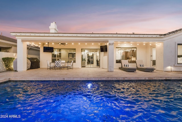 rear view of house with ceiling fan and a patio area