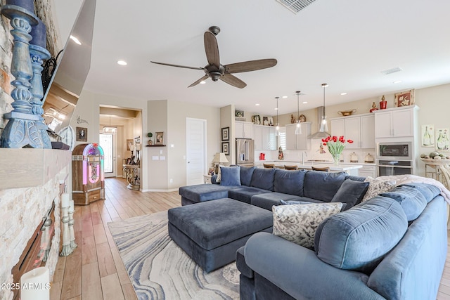 living room featuring light hardwood / wood-style floors and ceiling fan