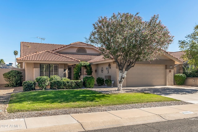 mediterranean / spanish-style house featuring a garage and a front lawn